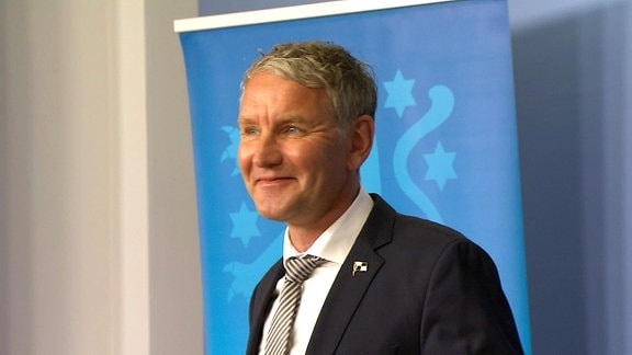 Björn Höcke vor blauem Aufsteller